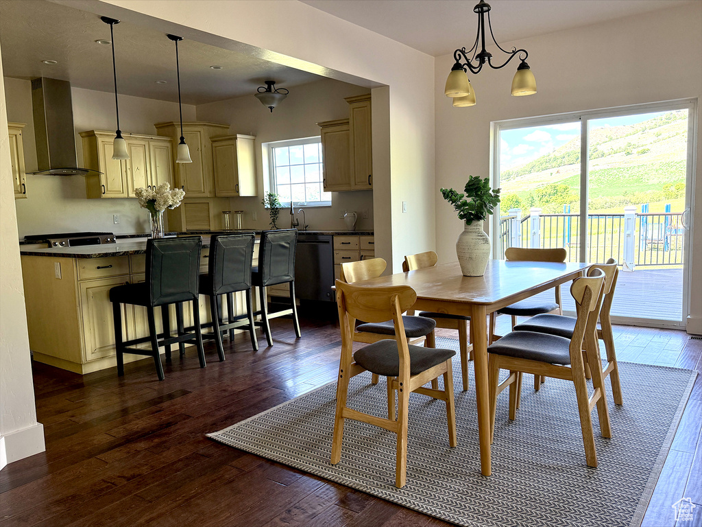 Dining area with dark wood-type flooring and a chandelier