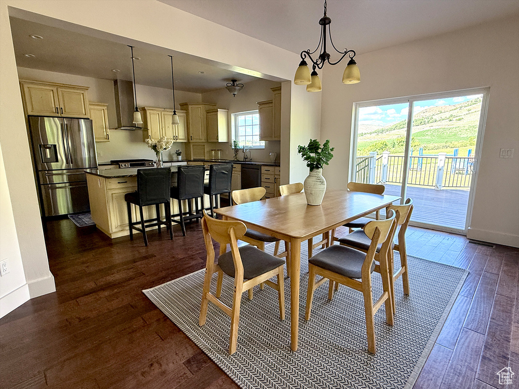 Dining room with dark wood-style floors and a chandelier