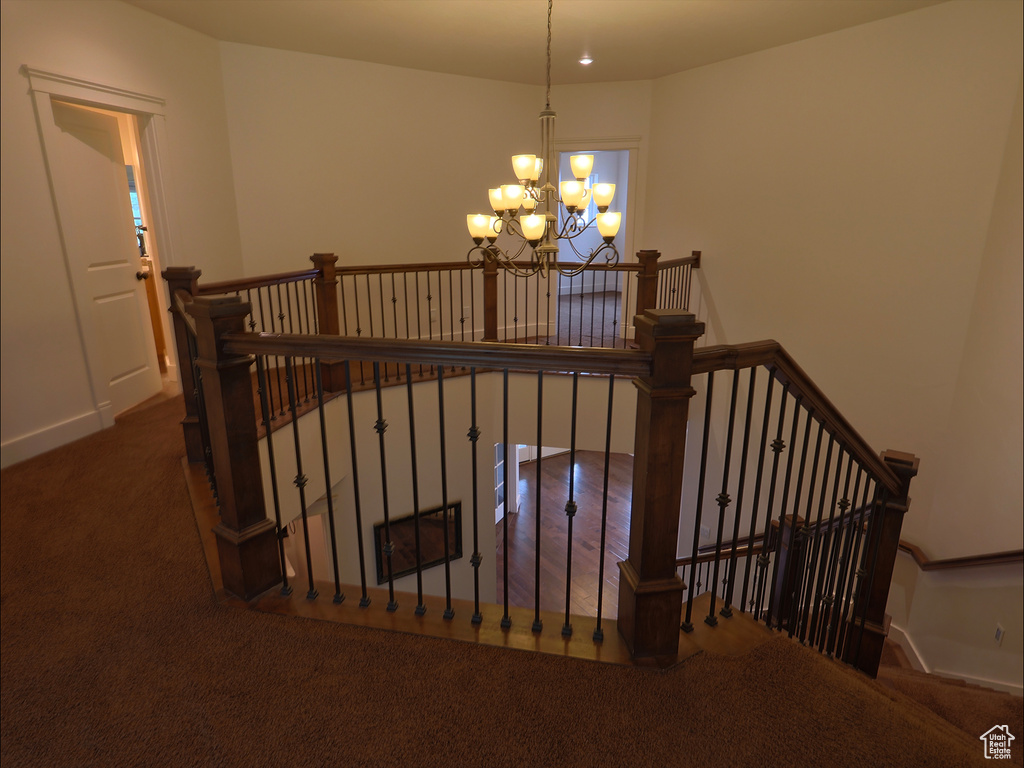 Stairway featuring a chandelier, carpet flooring, and baseboards