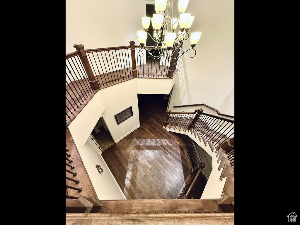 Stairs with a chandelier and wood finished floors