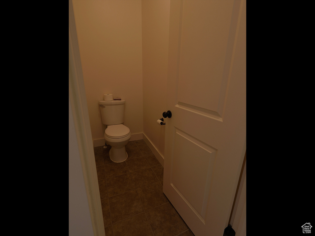 Bathroom with tile patterned flooring, toilet, and baseboards