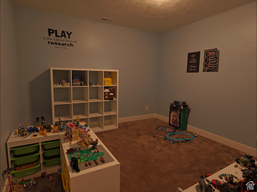 Game room with carpet, a textured ceiling, and baseboards