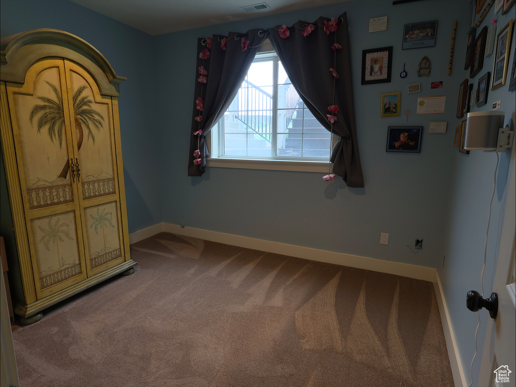 Carpeted empty room featuring baseboards