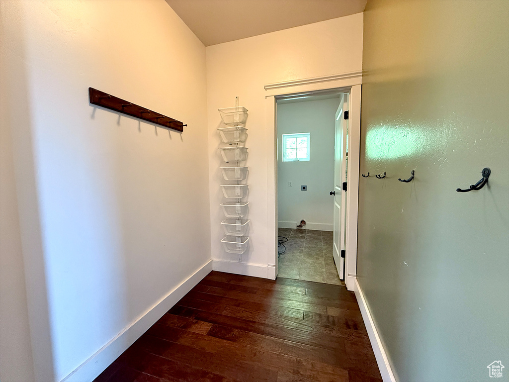 Hallway featuring dark wood-style floors and baseboards