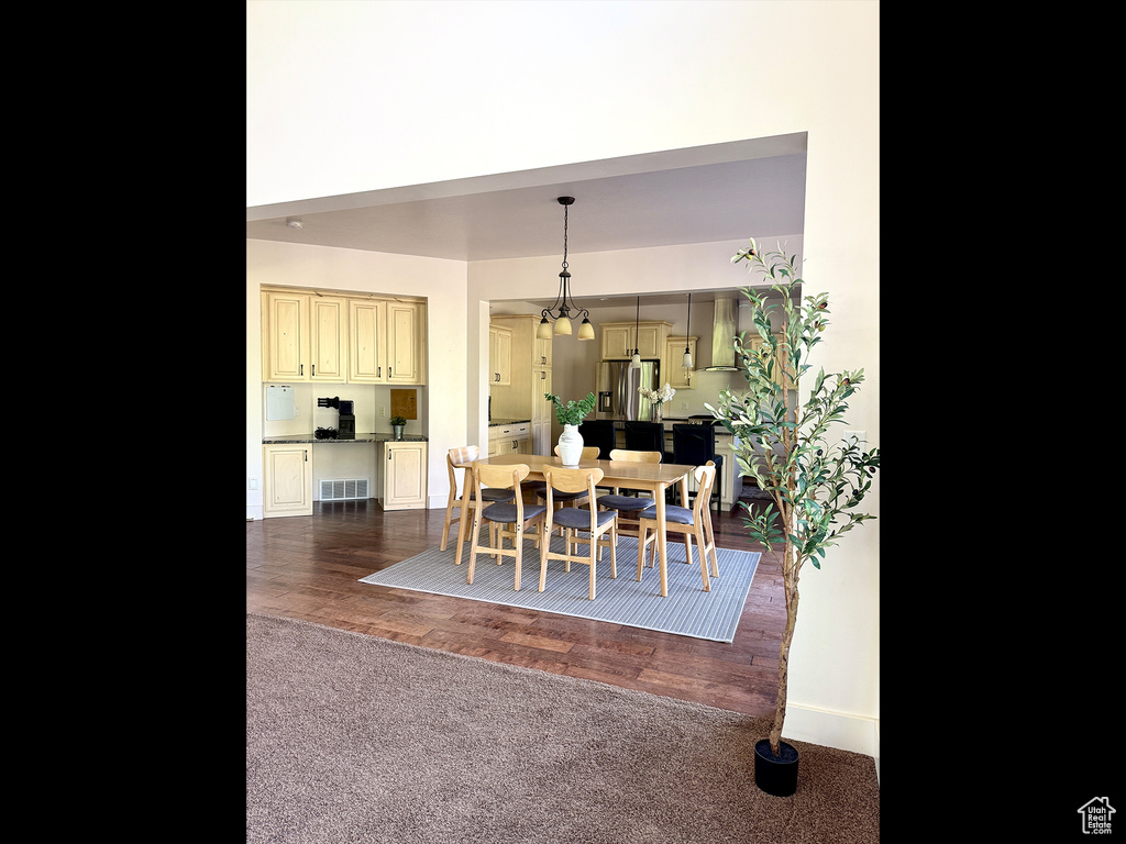 Dining room with dark colored carpet and dark wood-style flooring