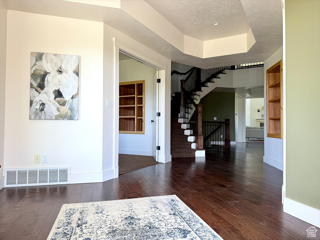 Foyer entrance with hardwood / wood-style flooring and stairs