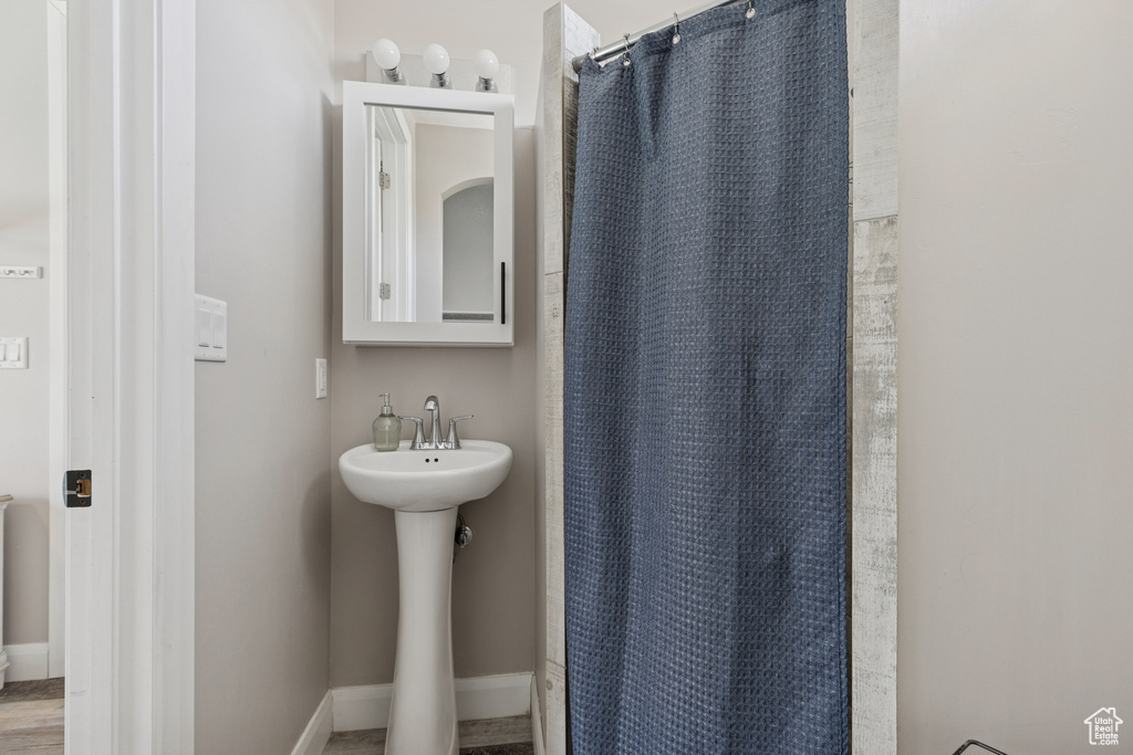 Bathroom with a shower with curtain, a sink, and baseboards