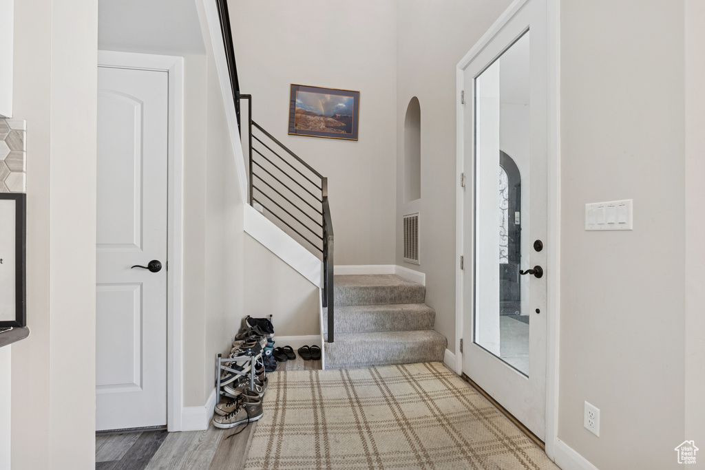 Foyer featuring arched walkways, stairs, and baseboards