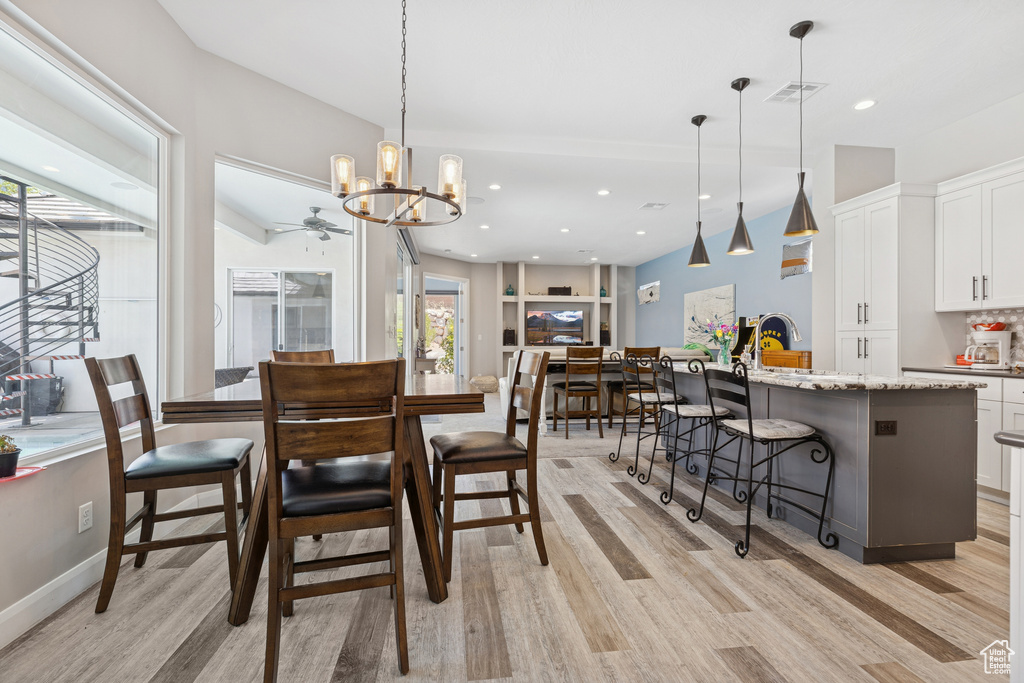 Dining area featuring light wood-type flooring, a chandelier, recessed lighting, and a ceiling fan