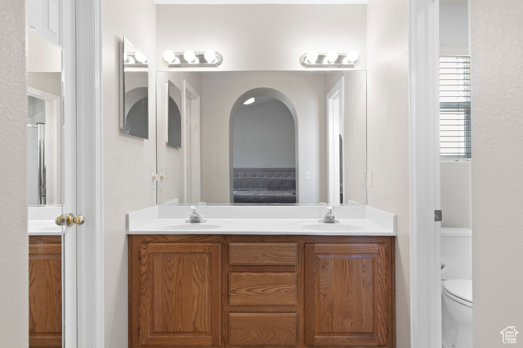 Full bath with double vanity, toilet, and ensuite bath