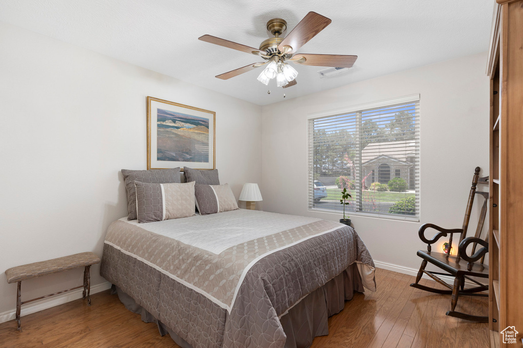 Bedroom featuring baseboards, light wood-style floors, and a ceiling fan