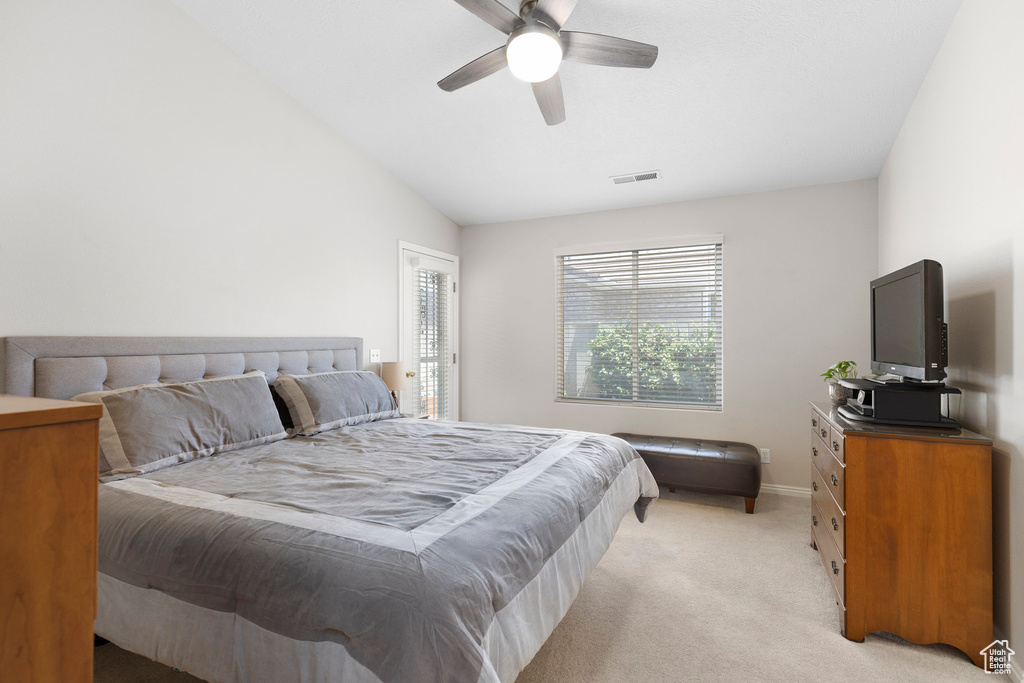 Bedroom with light carpet, vaulted ceiling, baseboards, and ceiling fan