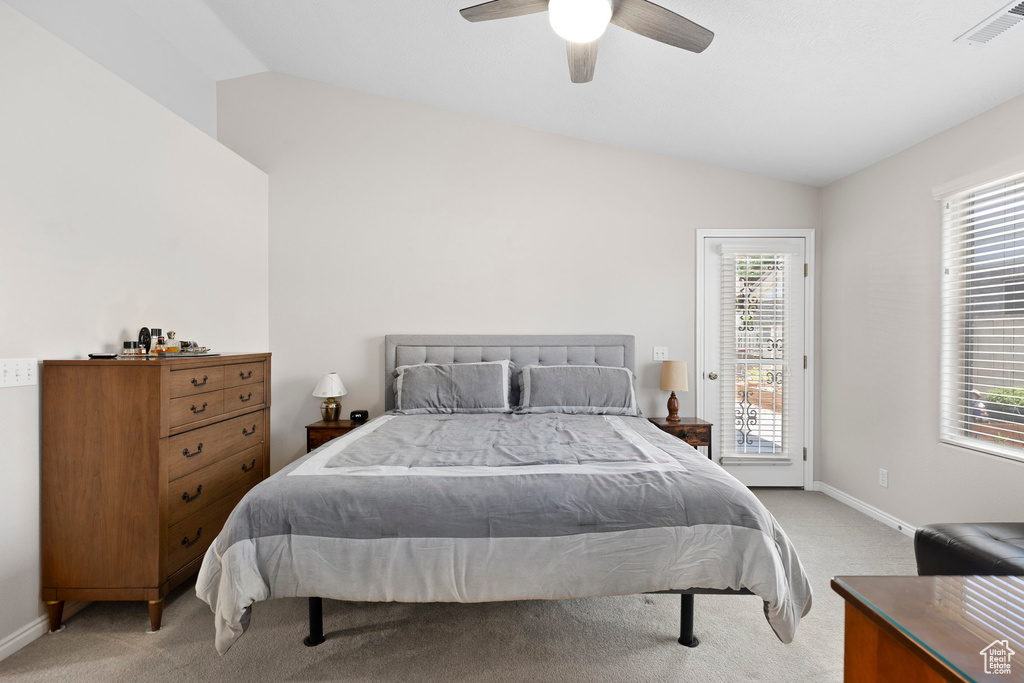 Bedroom with lofted ceiling, light colored carpet, access to outside, baseboards, and a ceiling fan