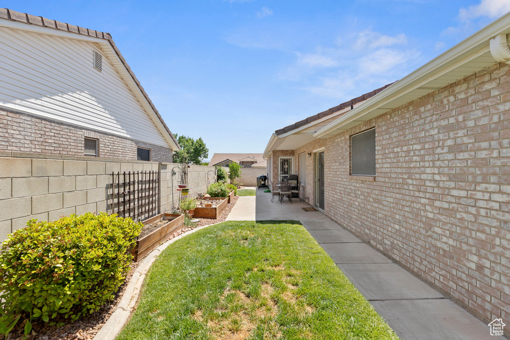 View of yard featuring a vegetable garden and a patio
