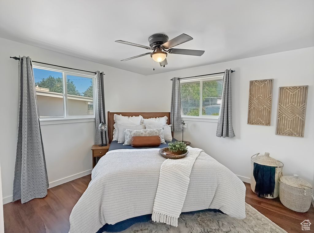 Bedroom with multiple windows, wood finished floors, and baseboards