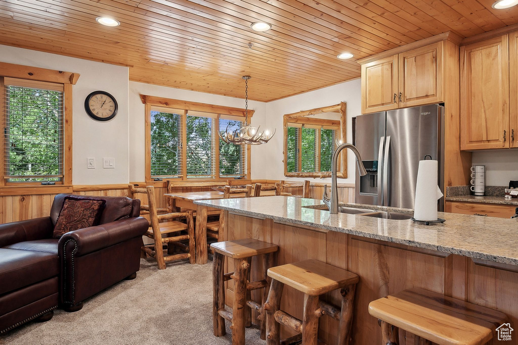 Kitchen with stainless steel fridge, wooden ceiling, recessed lighting, plenty of natural light, and a kitchen bar