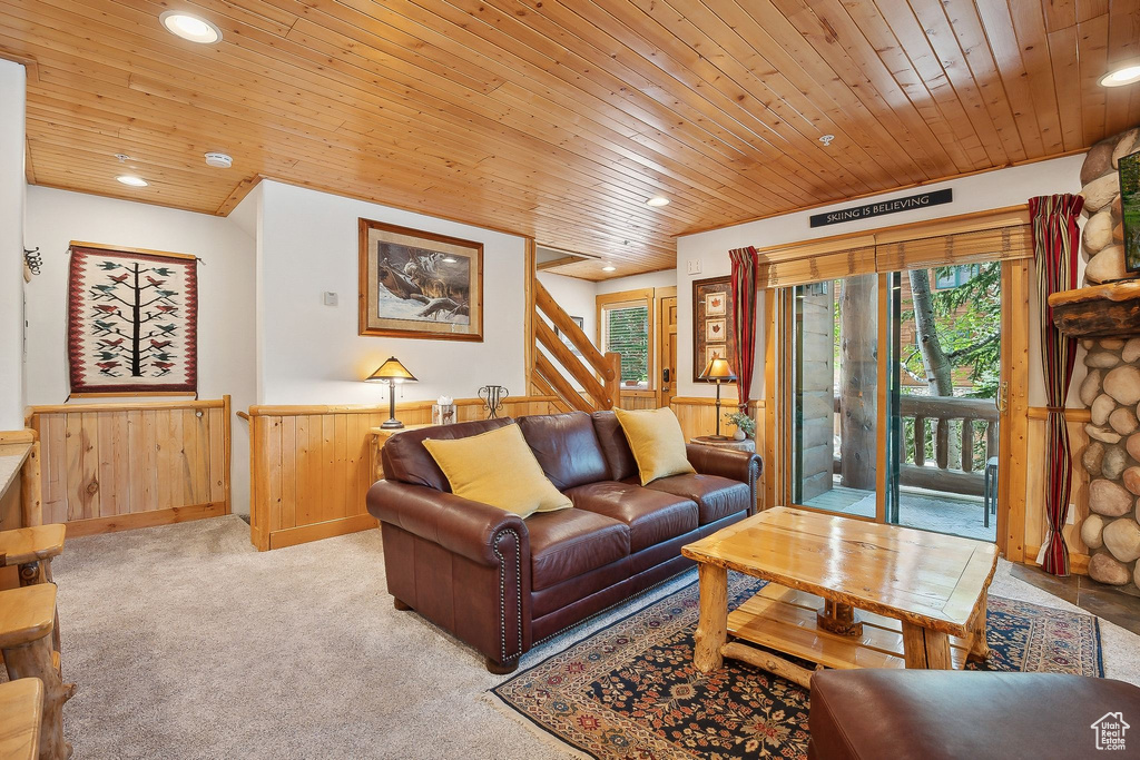 Living room featuring a wainscoted wall, wooden ceiling, recessed lighting, wood walls, and light colored carpet