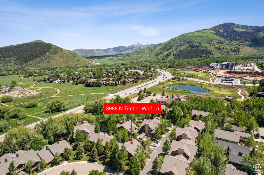 Aerial view of property and surrounding area with nearby suburban area and a water and mountain view