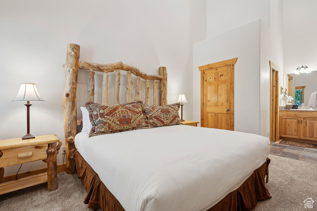 Bedroom with a high ceiling, carpet, and ensuite bathroom