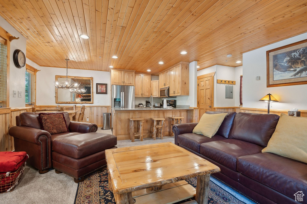 Living area featuring wooden ceiling, a wainscoted wall, light carpet, a chandelier, and recessed lighting