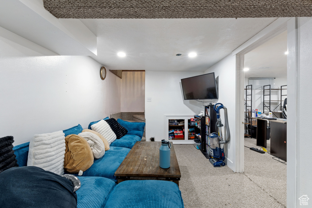 Carpeted living area with baseboards and recessed lighting