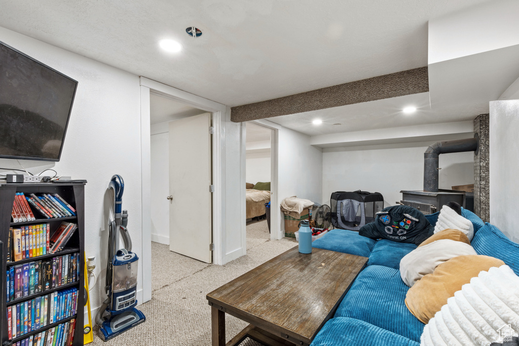 Living room with carpet floors, recessed lighting, and a wood stove