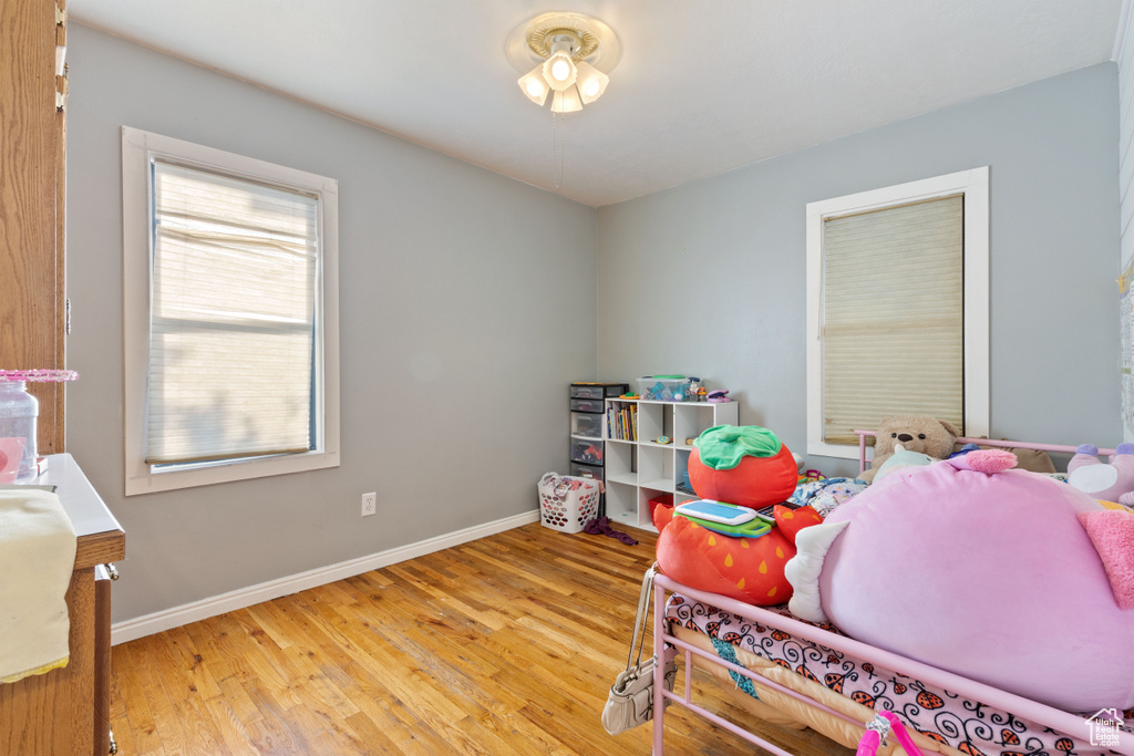 Bedroom featuring multiple windows, wood finished floors, and baseboards