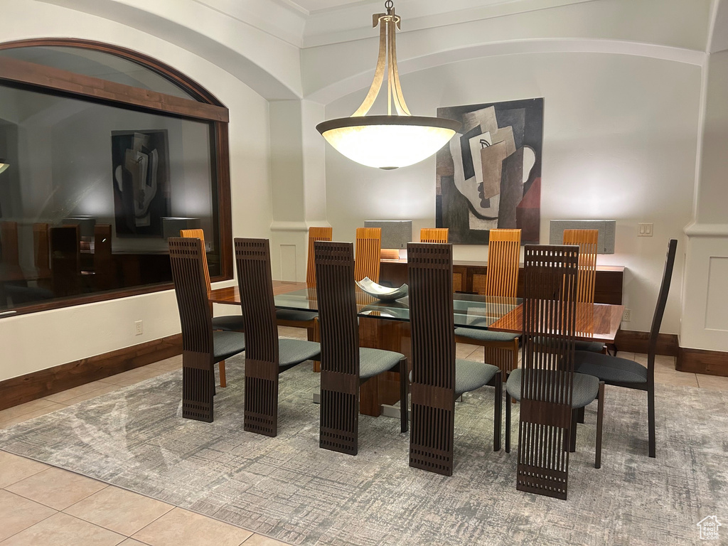 Tiled dining room featuring ornamental molding