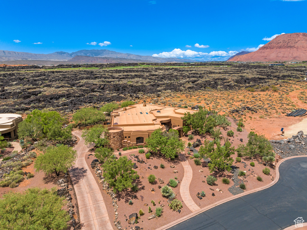 View from above of property featuring a mountain backdrop and a desert landscape