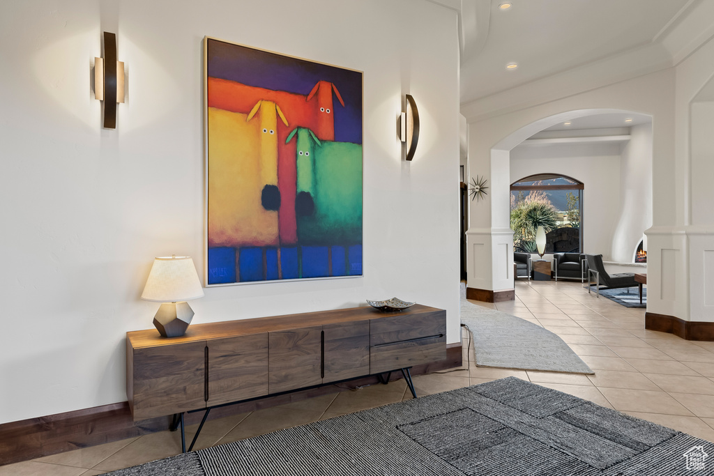 Hall with arched walkways, tile patterned floors, recessed lighting, and baseboards