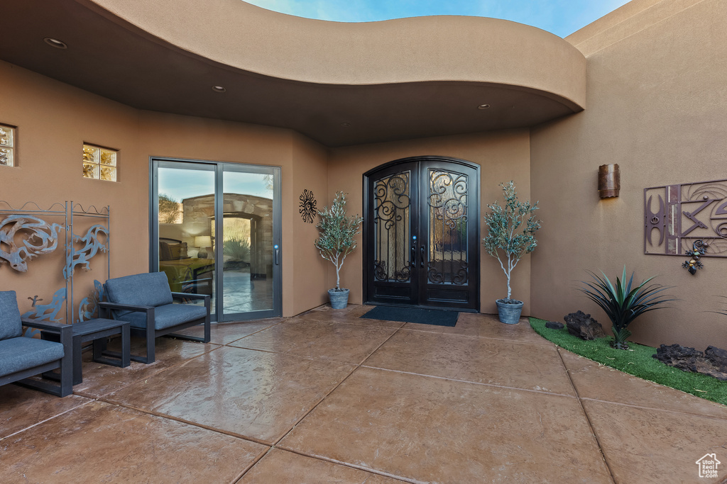 Property entrance with stucco siding, french doors, and a patio