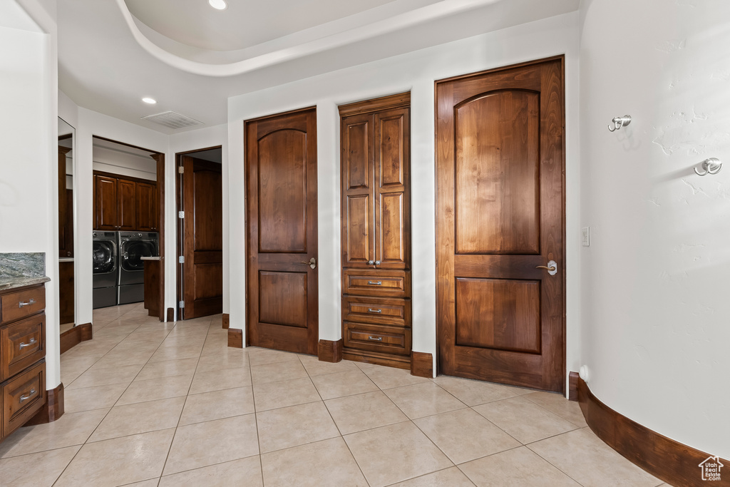Unfurnished bedroom featuring washing machine and clothes dryer, light tile patterned floors, baseboards, and recessed lighting