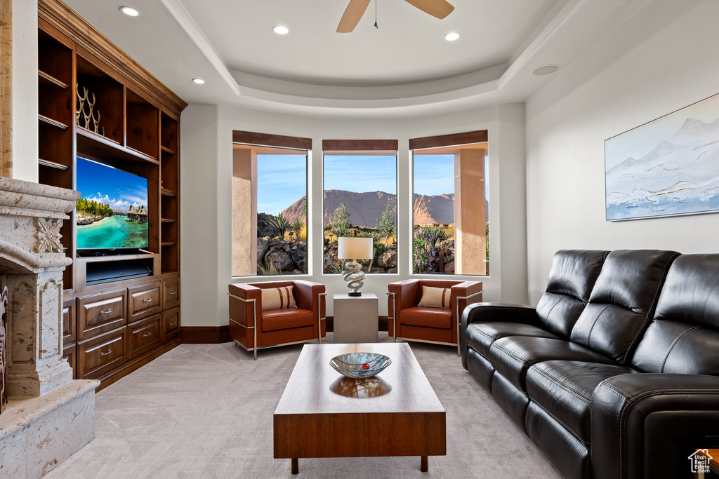 Living room featuring light colored carpet, recessed lighting, ceiling fan, and a raised ceiling