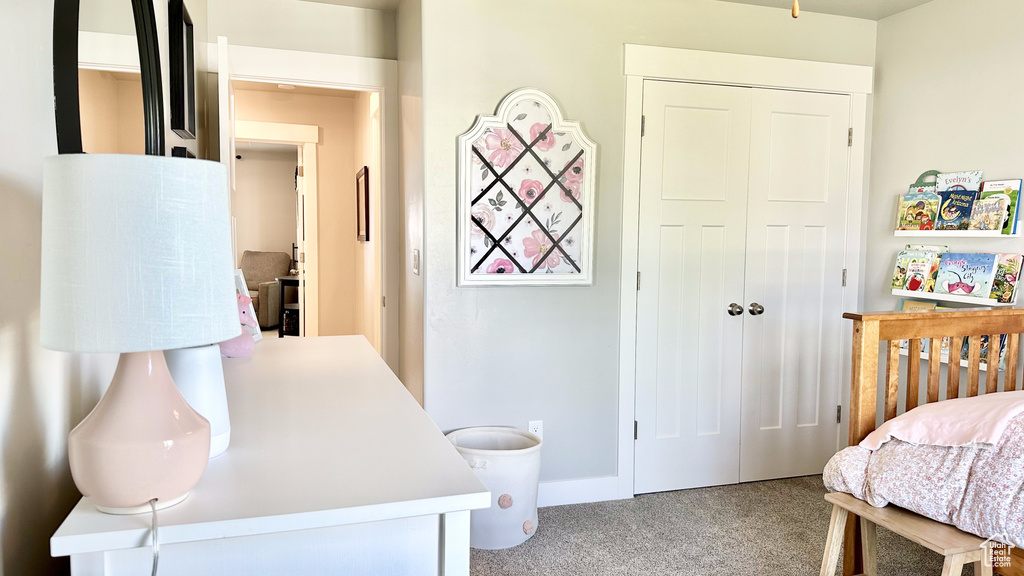 Carpeted bedroom with a closet and baseboards