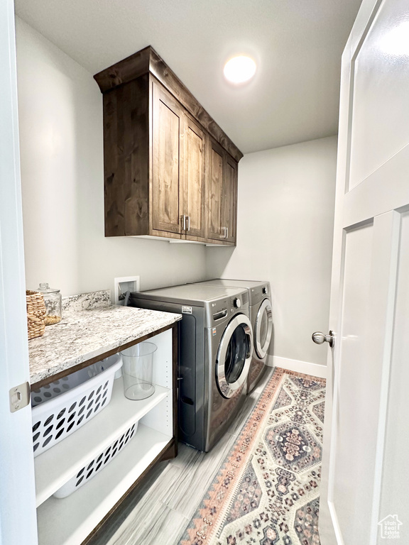 Laundry room with cabinet space, separate washer and dryer, and baseboards
