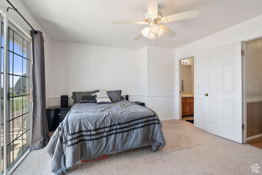Bedroom with carpet, baseboards, a ceiling fan, and ensuite bath