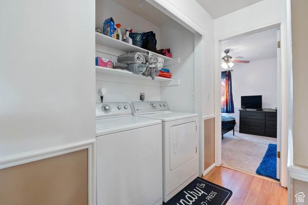 Washroom with washing machine and clothes dryer, light wood-style floors, and a ceiling fan