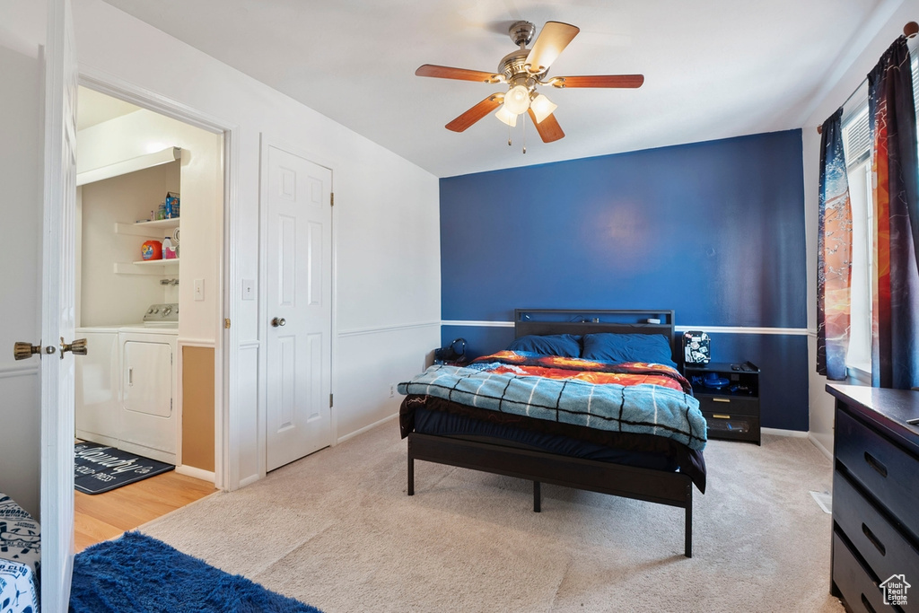 Carpeted bedroom featuring washing machine and clothes dryer and ceiling fan