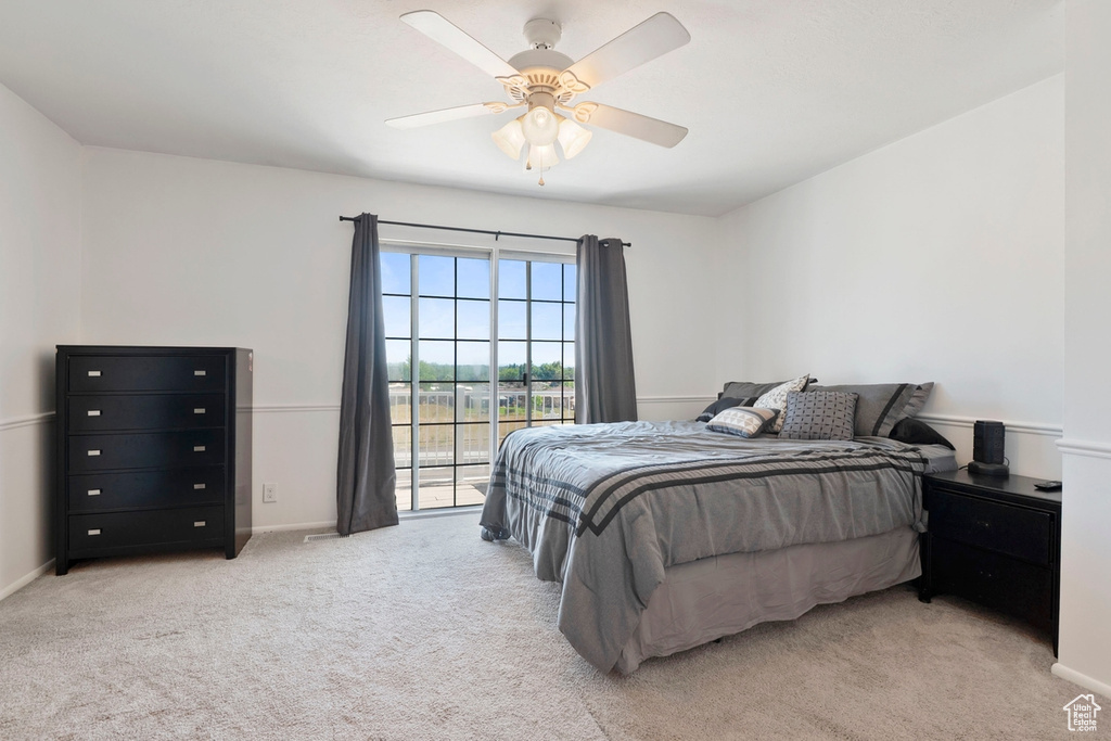 Bedroom featuring light colored carpet, access to outside, a ceiling fan, and baseboards