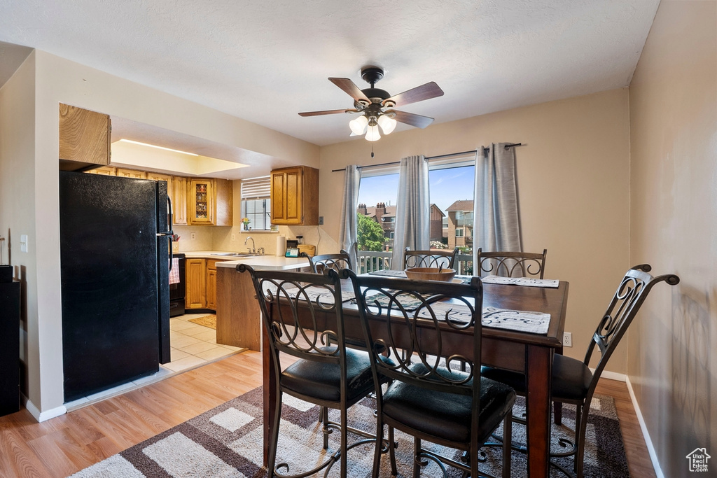 Dining space with ceiling fan and light wood-style flooring