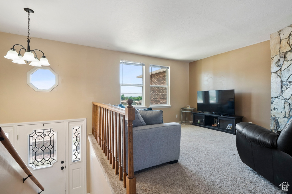 Carpeted living area with a chandelier