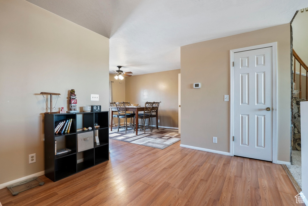 Foyer with a ceiling fan, light wood-style floors, and baseboards