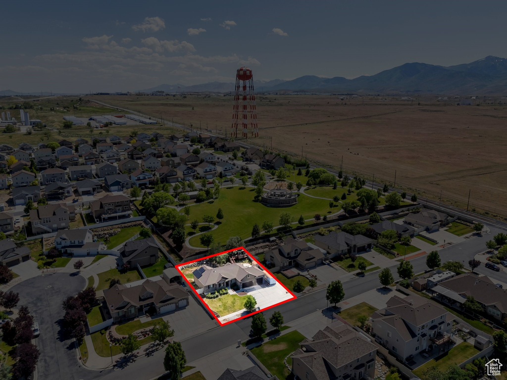 Aerial view of property and surrounding area with property parcel outlined, a mountainous background, and nearby suburban area