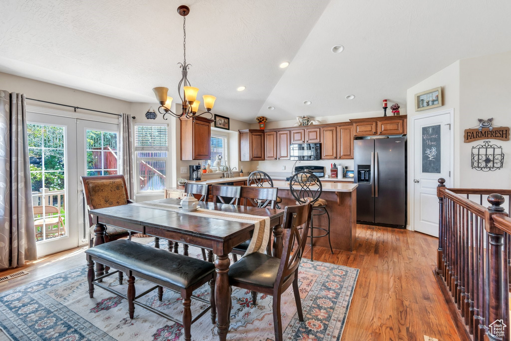 Dining space featuring a chandelier, lofted ceiling, plenty of natural light, light wood-style floors, and recessed lighting