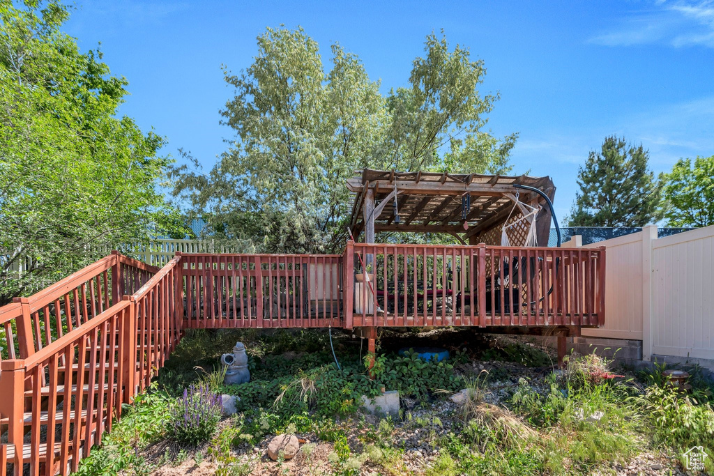 Deck featuring a pergola and a fenced backyard