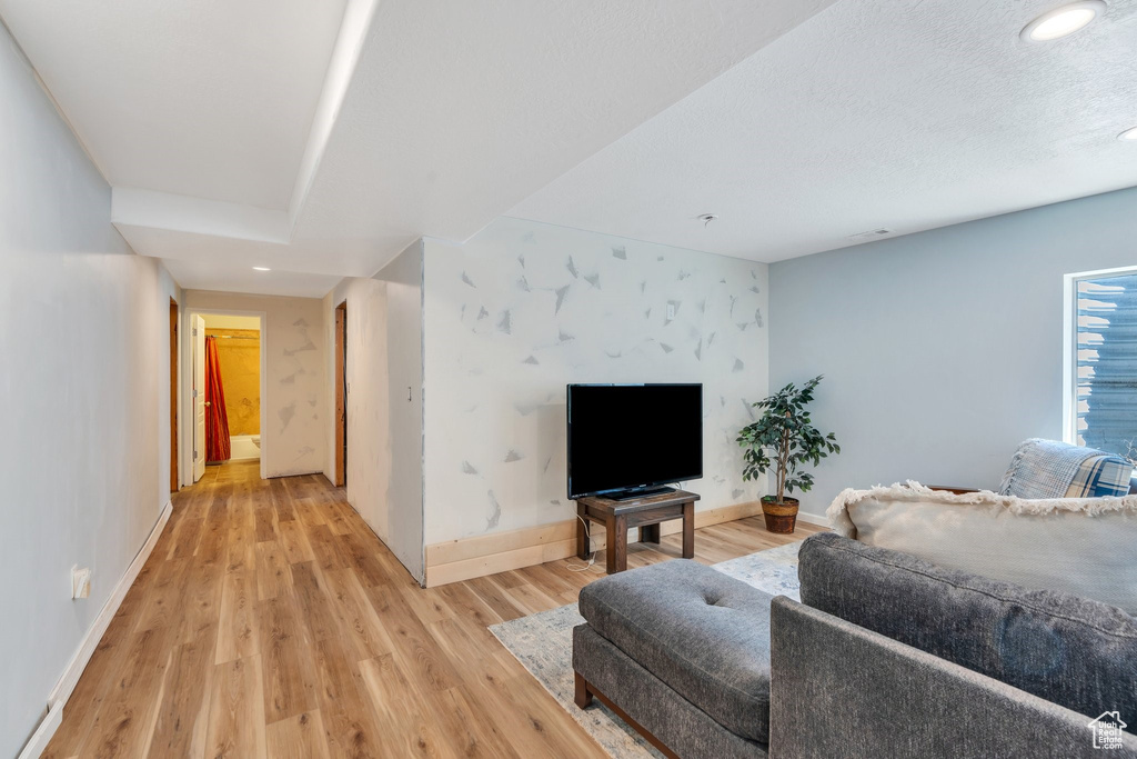 Living room featuring baseboards, light wood-style floors, and recessed lighting