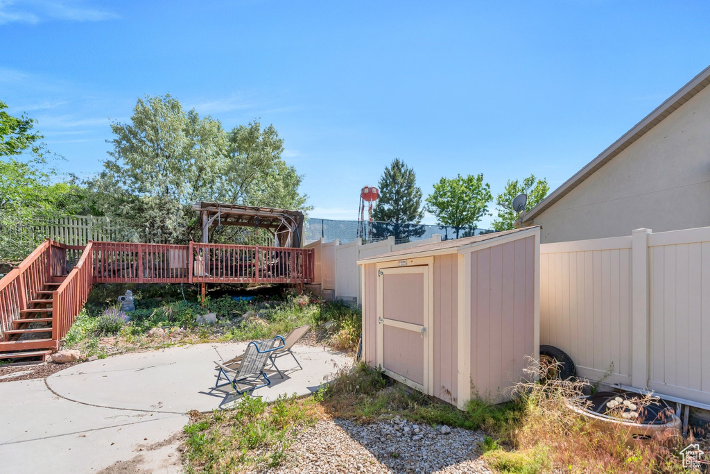 Fenced backyard with a patio, a wooden deck, and stairs