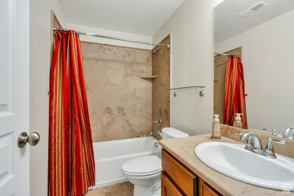 Bathroom with shower / bathtub combination with curtain, toilet, vanity, and tile patterned floors