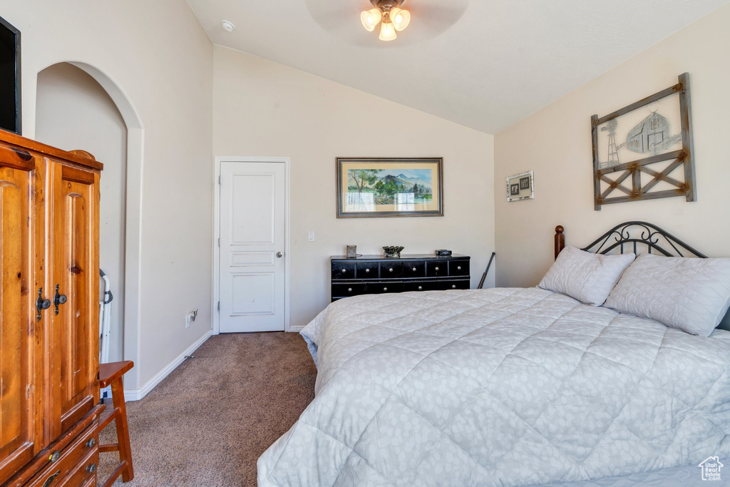 Bedroom with carpet flooring, vaulted ceiling, baseboards, and a ceiling fan