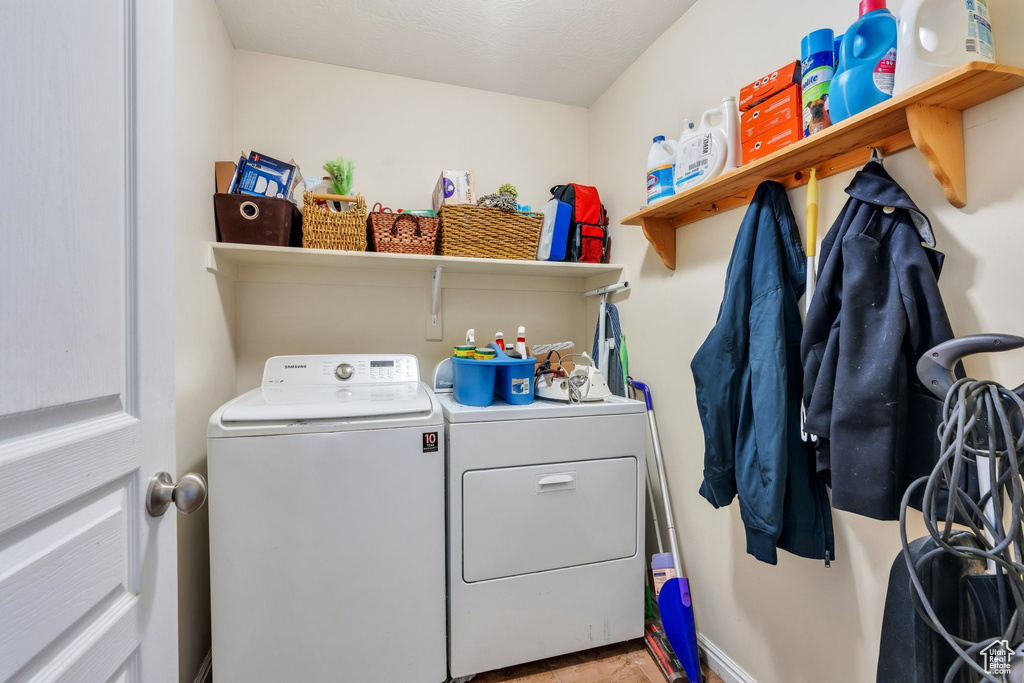 Washroom featuring washing machine and clothes dryer and baseboards